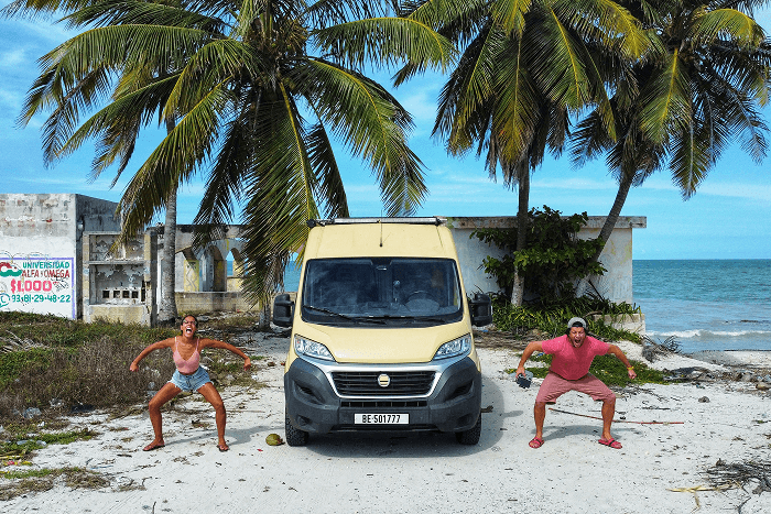Our time horizon is simple - @gary_and_sheila 06/2023 Gary and Sheila, the vanlife couple behind @gary_and_sheila, playfully posing in front of their self converted Fiat Ducato camper van parked on a sandy beach in Mexico lined with palm trees and the ocean in the background. The image captures tropical vanlife, beach camping, overland travel in Central America, and the freedom of long term life on the road.