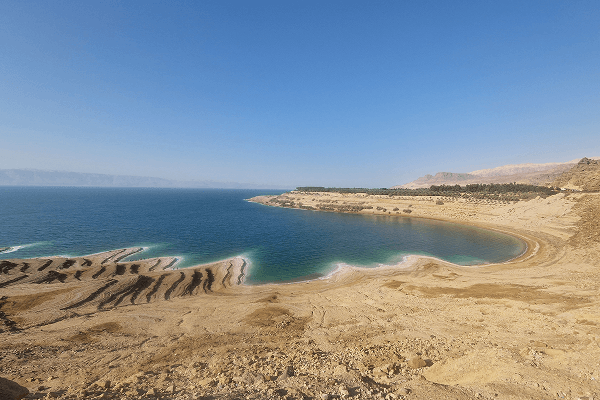 Panoramic view of the Dead Sea in Jordan - @paul.jaunegg 03/2023 Panoramic view of the Dead Sea in Jordan, showing its calm turquoise waters, mineral-rich shoreline, and surrounding desert mountains under a clear blue sky. The image highlights the region’s unique natural beauty and geological features. Photo by Paul Jaunegg.