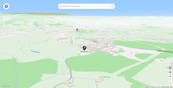 A standard location at vanlifezone.com/map Screenshot of a map view from vanlifezone.com/map displaying the location of Steirervan in Hartberg, Austria. The map features a 3D view of the area with labeled landmarks, including Schildbach creek, nearby roads like L401, and a campsite icon in the vicinity. The map highlights Steirervan's position with a wrench symbol for easy identification, surrounded by green fields and small building clusters.
