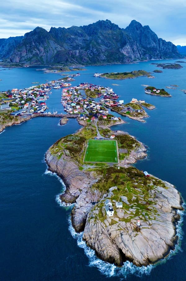 Aerial view of the iconic Henningsvær football field, in the Lofoten Islands, Norway - @van4life__ 10/2024 Aerial view of the iconic Henningsvær football field, located on a rocky island in the Lofoten Islands, Norway. Surrounded by dramatic mountains and the North Sea, this unique football pitch is nestled in the scenic fishing village of Henningsvær, highlighting the striking natural beauty and remote charm of the region.
